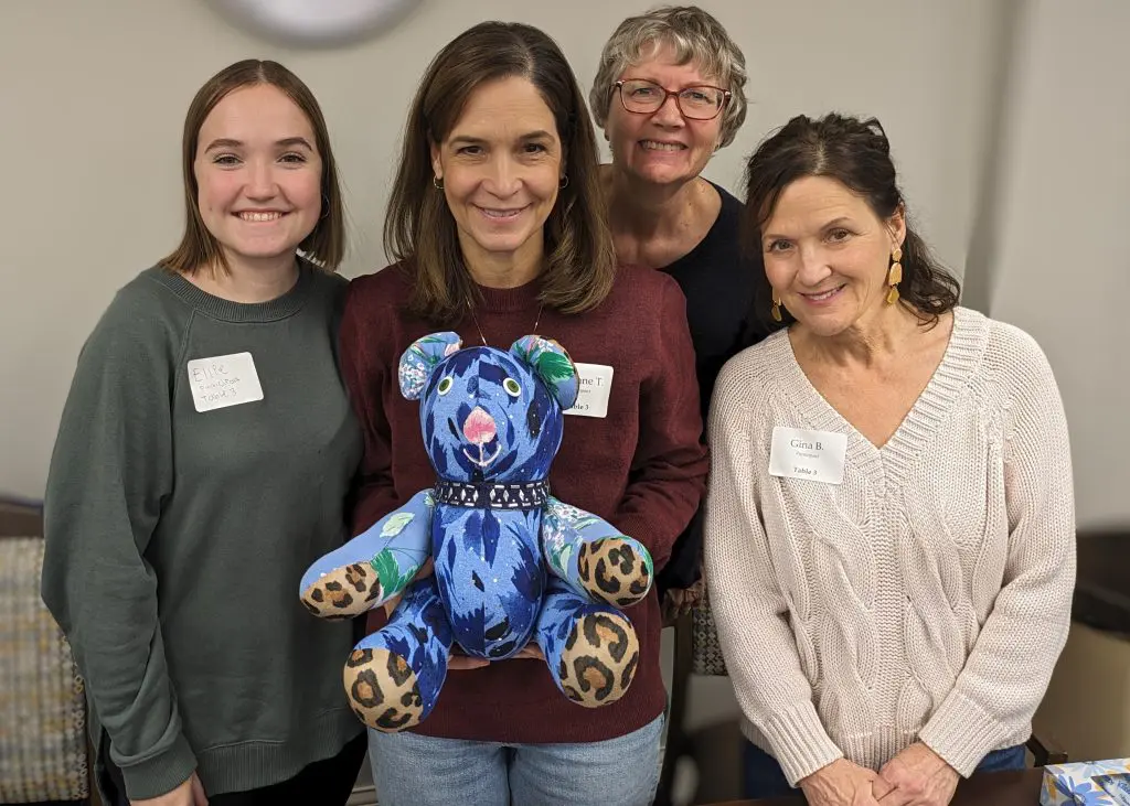 Family of four with a teddy bear made from their loved one's clothing