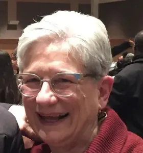 Ann-Sweeney - Our Lady of Peace A close up picture of Ann Sweeney. She is smiling wearing glasses and a red top