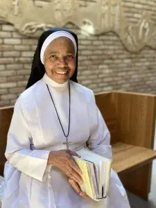a close up of Sister Polsy sitting in the chapel pew holding her bible