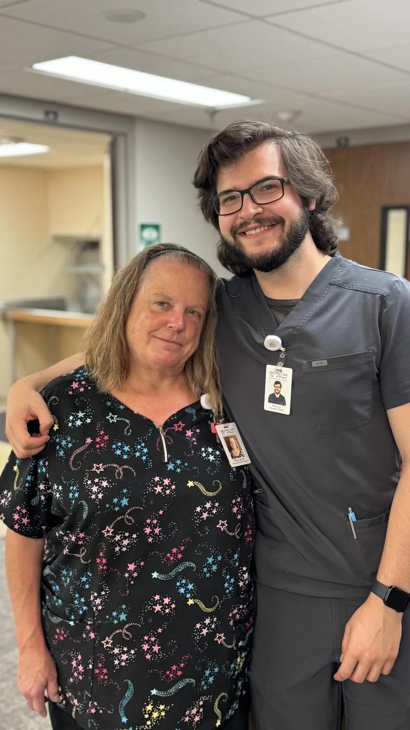 Two nurses smiling at the camera. MaryJo and Peter
