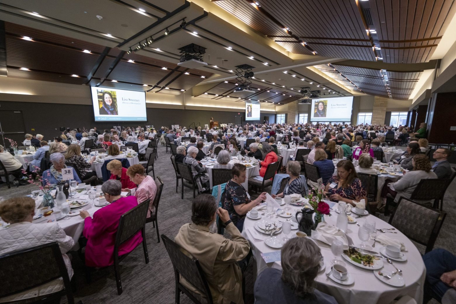 a room shot of the luncheon with all the attendees eating at tables