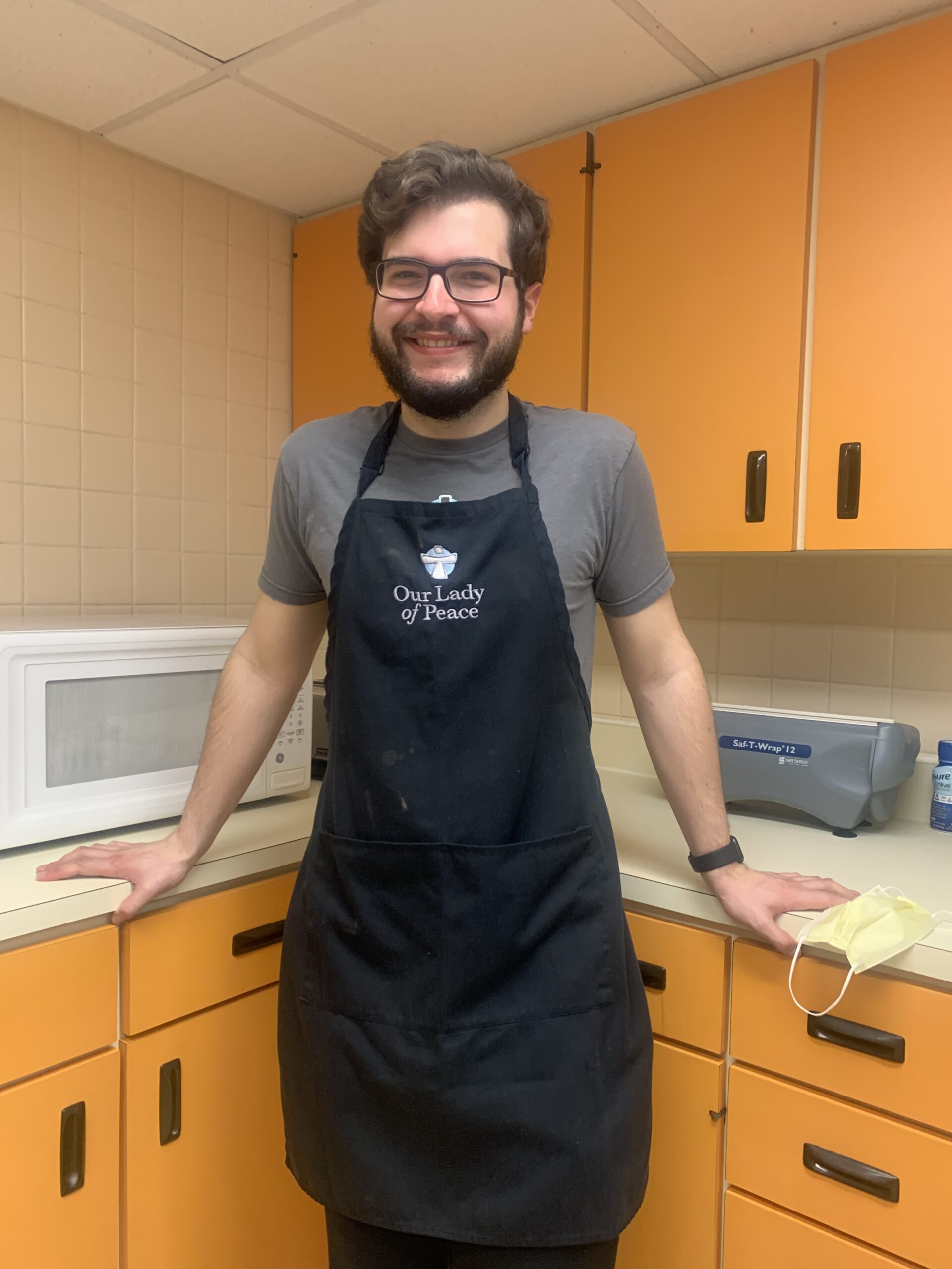 Picture of a smiling man wearing an apron.